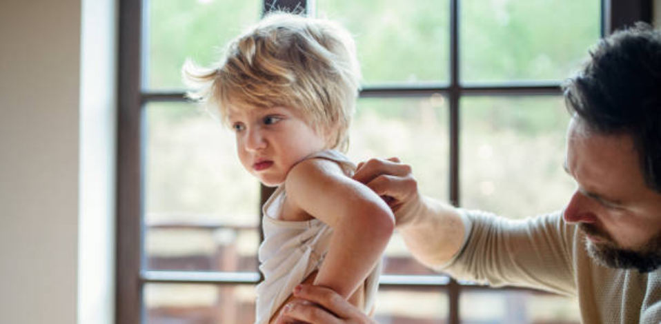 Child with eczema showing symptoms of dry, itchy skin and redness on arms