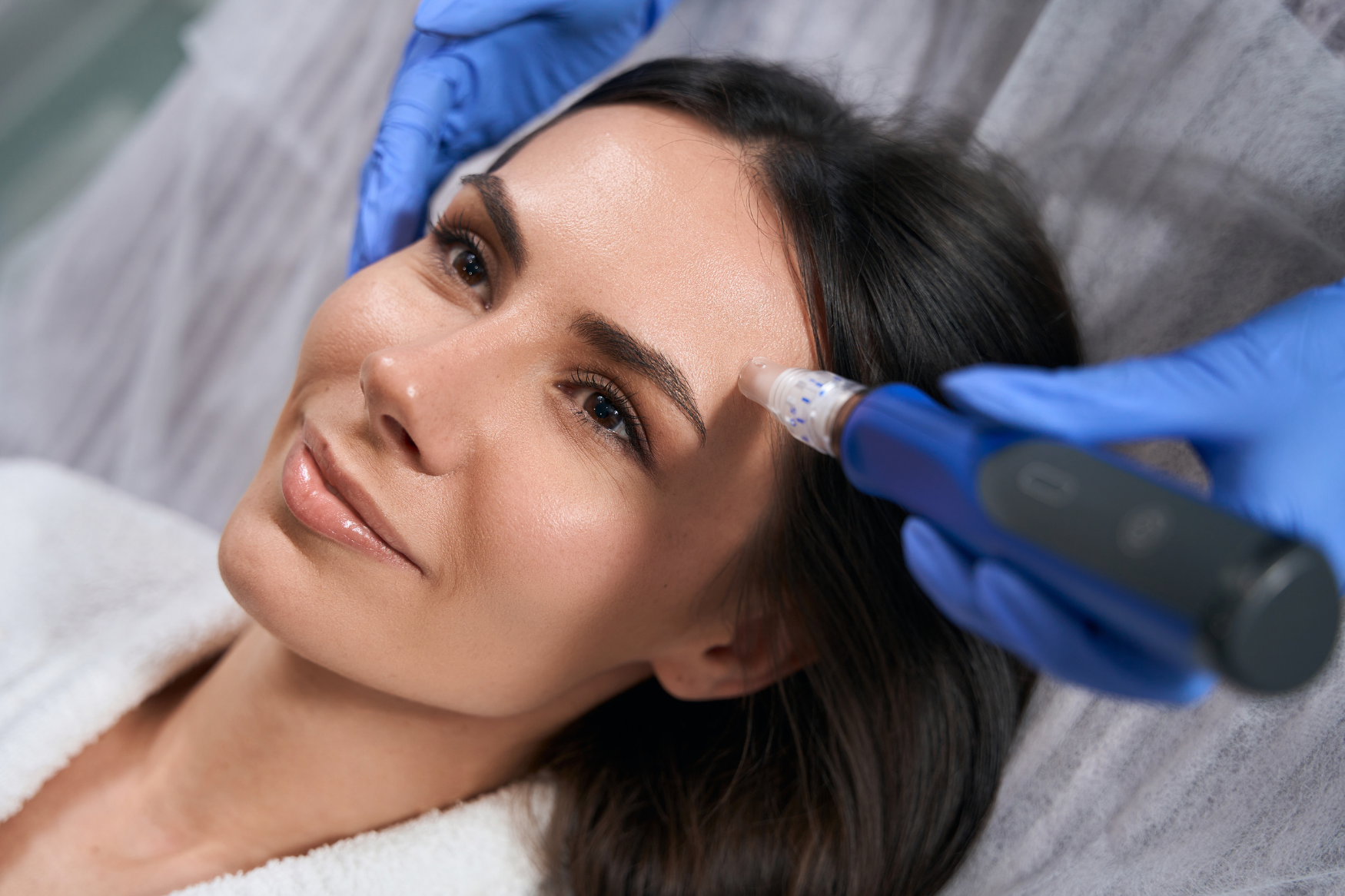 Dermatologist performing professional microneedling treatments to rejuvenate skin and boost collagen production at The DERM Center